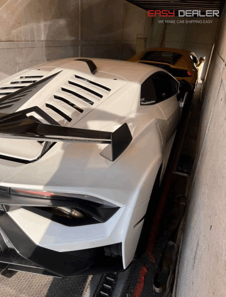 White and yellow Lamborghini inside an enclosed car transport trailer