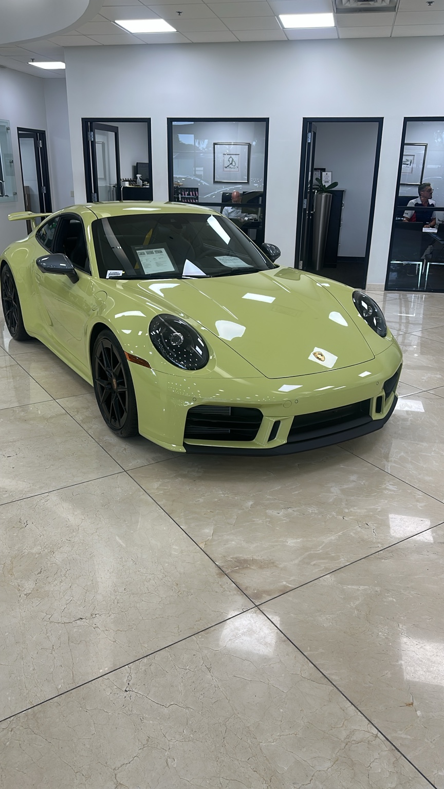 Light green Porsche inside a dealership showroom